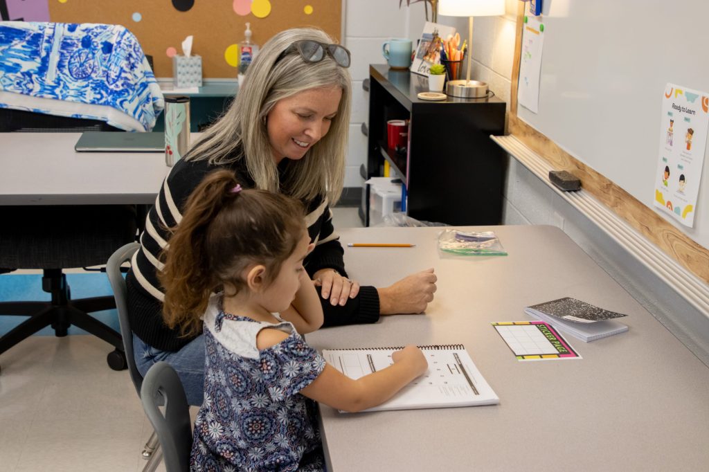 A teacher works with a student