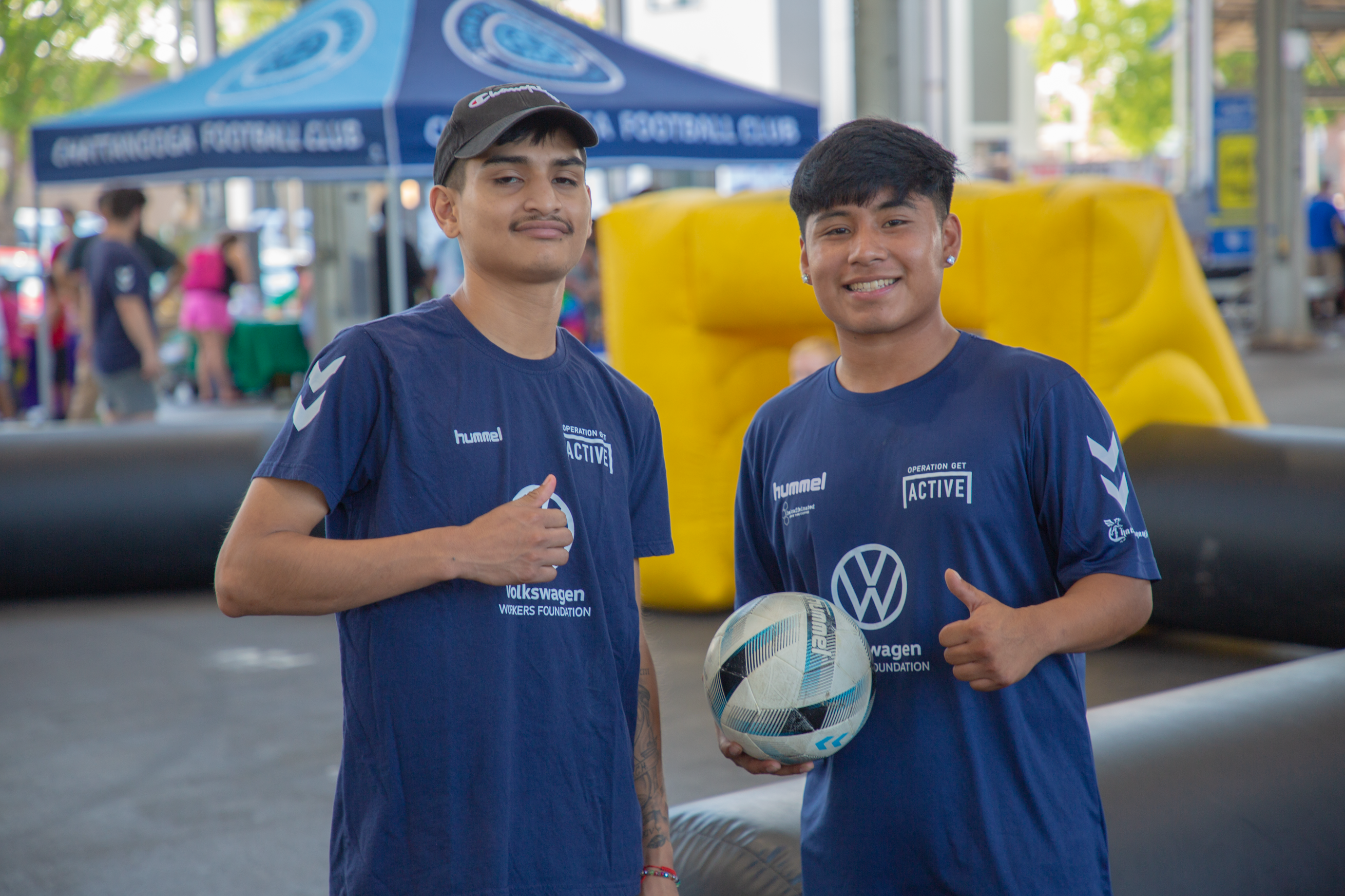Two boys hold a soccer ball and smile for a photo