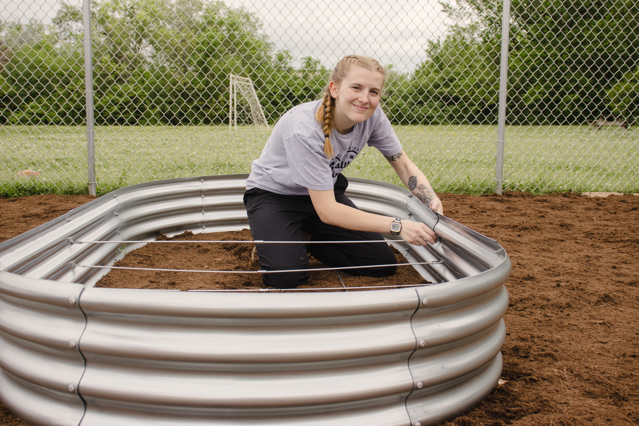A student works in a flower bed