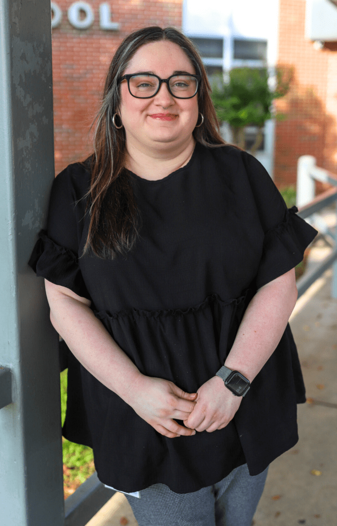 A teacher poses for a photo