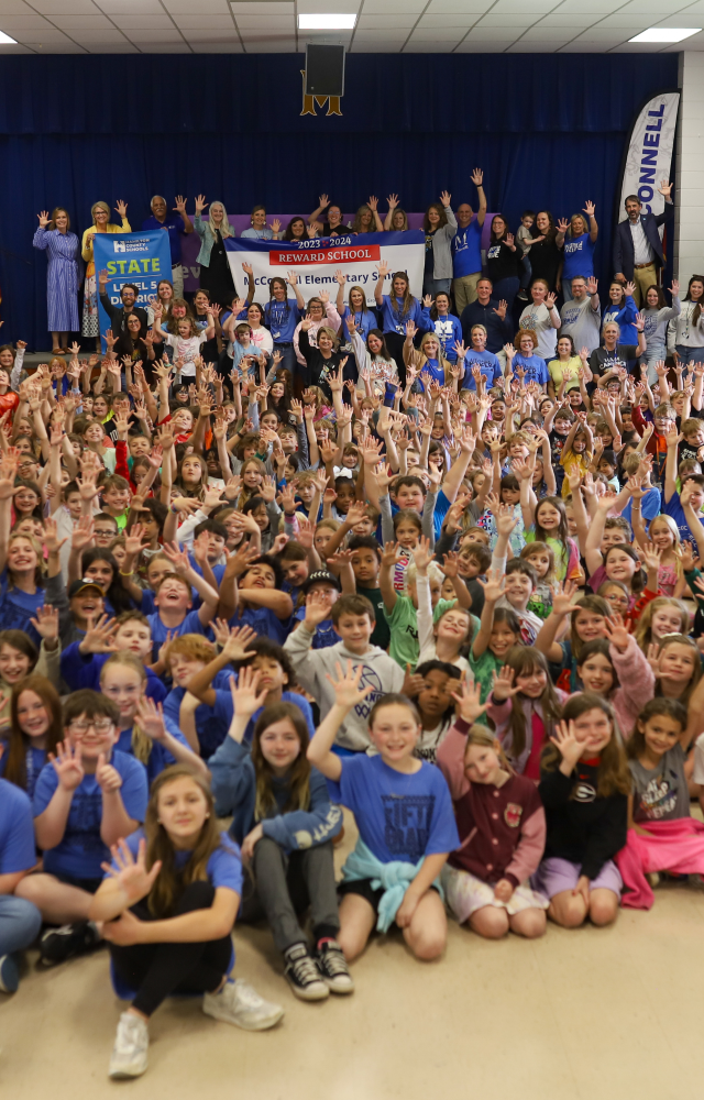 NEWSROOM COVER - Storybook Trail-13 Students pose for a banner presentation photo