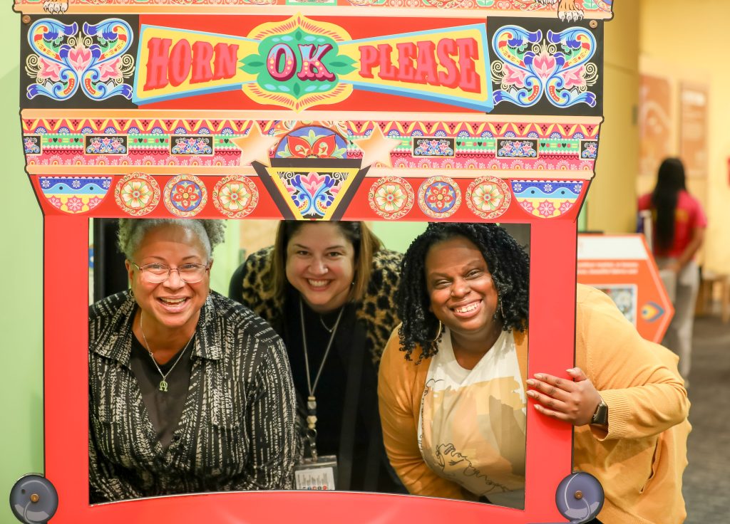 Three people smile for a photo