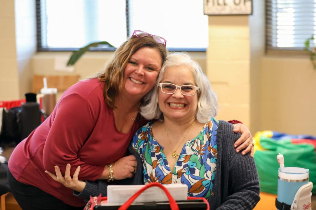 Two teachers smile