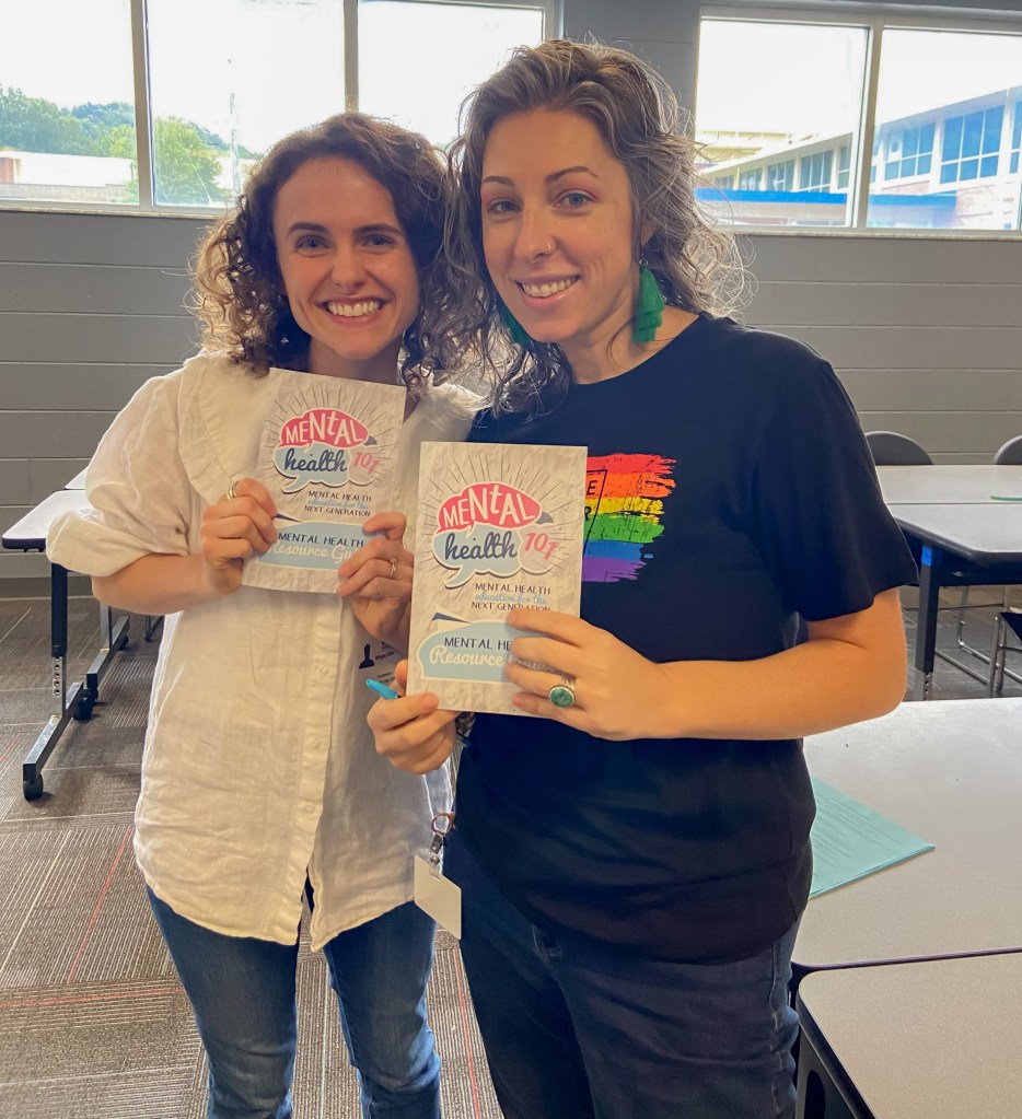 RBH Mental Health Week-17 two teachers / counselors holding up mental health 101 pamphlets at red bank high