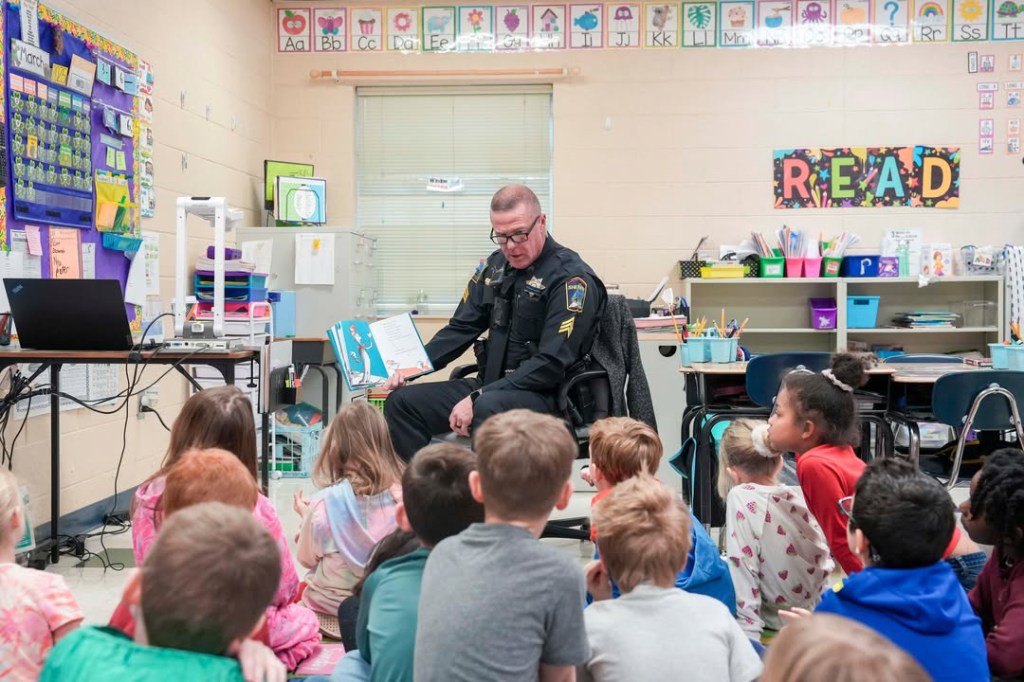 An officer reads to a class
