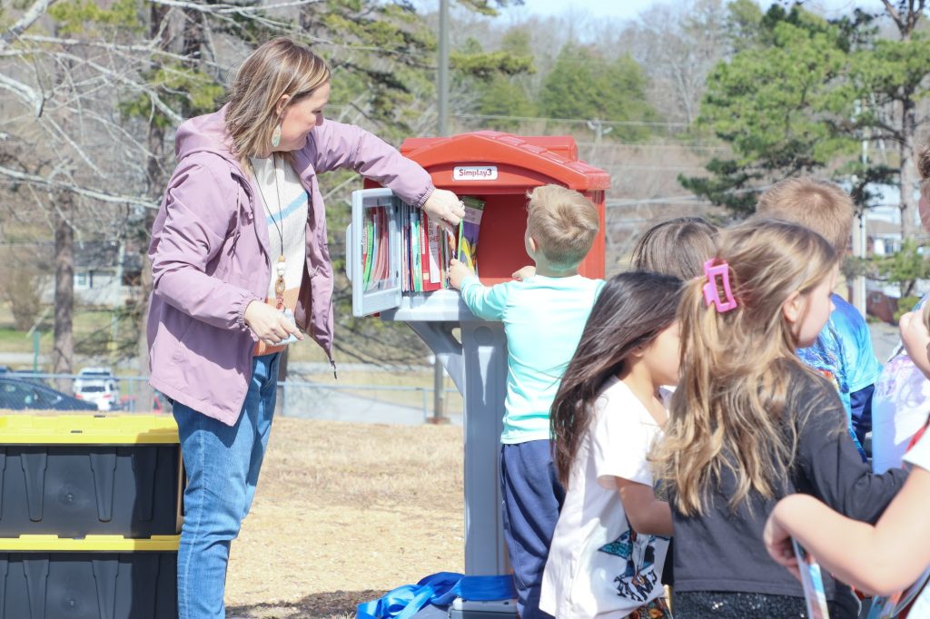 A teacher helps a student get a book