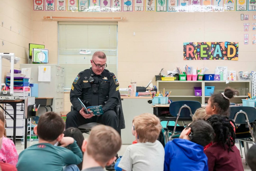 An officer reads to a class