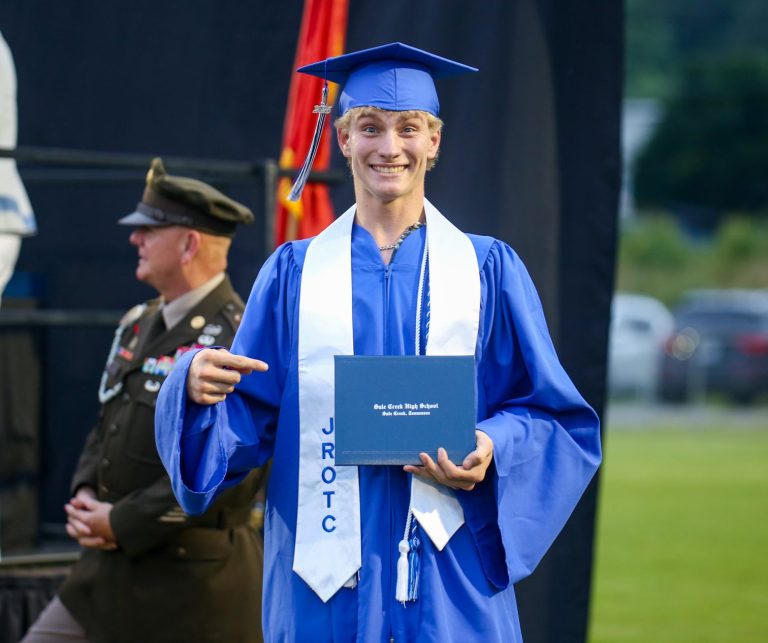 A graudate holds their diploma