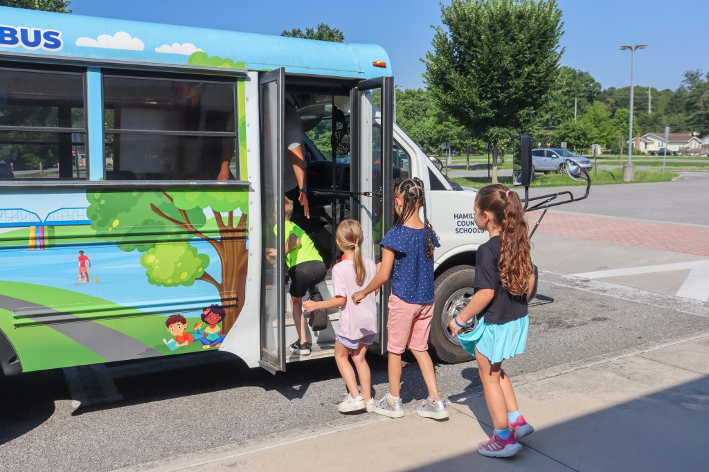 students getting on book bus