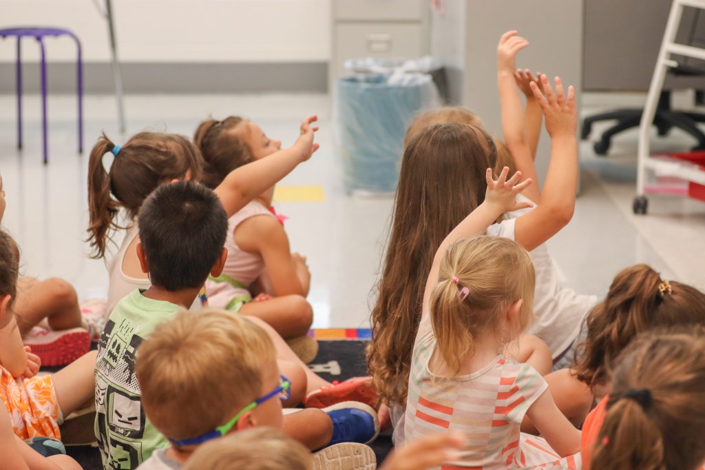students raising hands