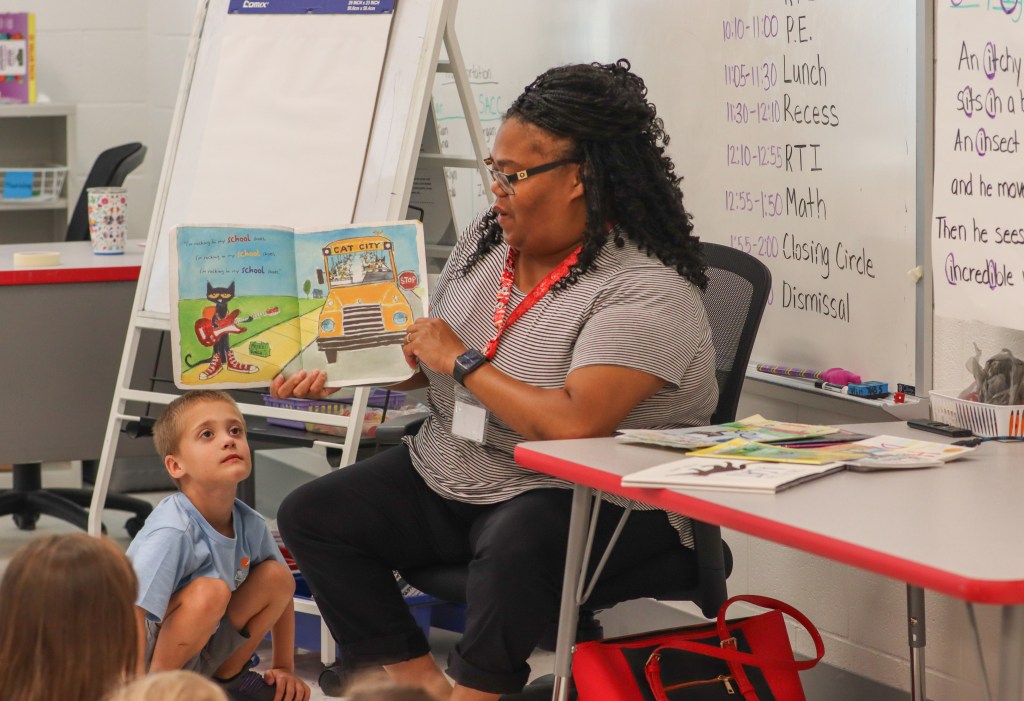 teacher reading book to elementary students