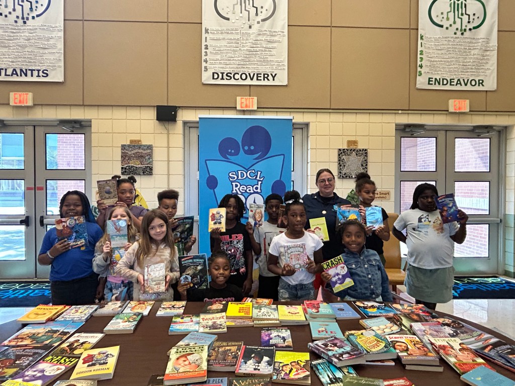 students holding books for SDCL Read 20