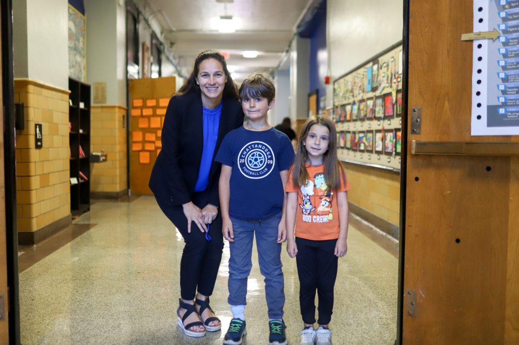 JAMJO-09 A woman poses for a photo with two students